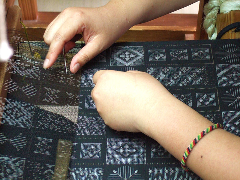 奄美・奄美大島の機織りは女性の仕事-絣目が細かいのでズレないように合わせながら織ります